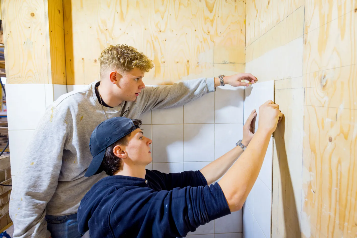 Student Tegelzetter oefenen in het praktijklokaal