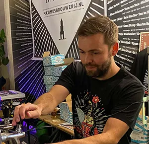 Man tapt bier bij stand van Maximus Brouwerij.