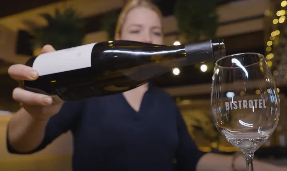 meisje schenkt wijn in een glas 