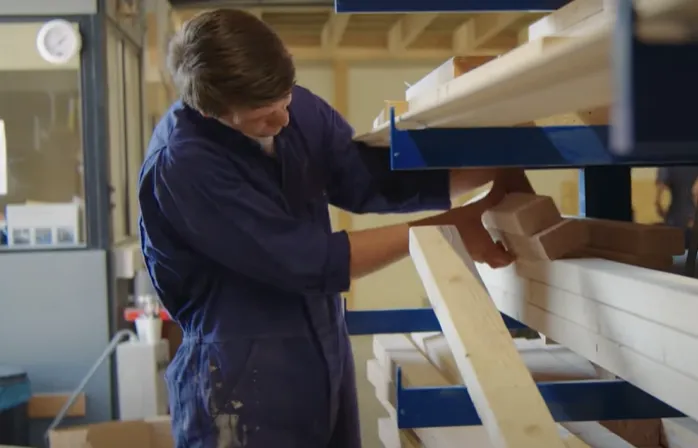 VEVA bouw jongen naast hout