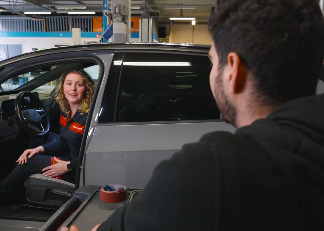 Student Automotive College zit achter het stuur van een auto