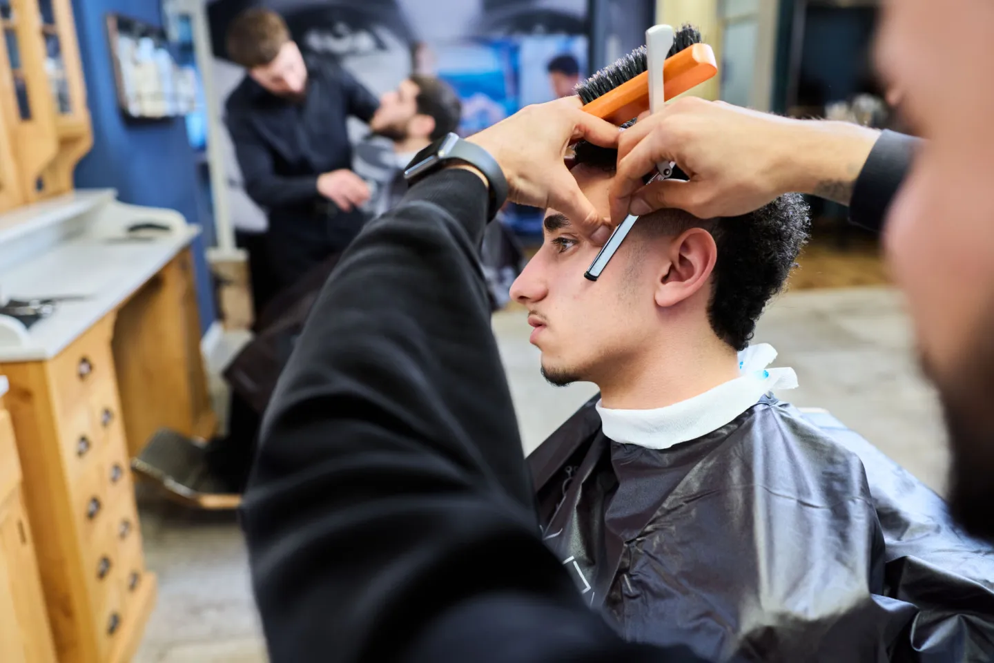 Student Barbier maakt klant mooi in schoolsalon