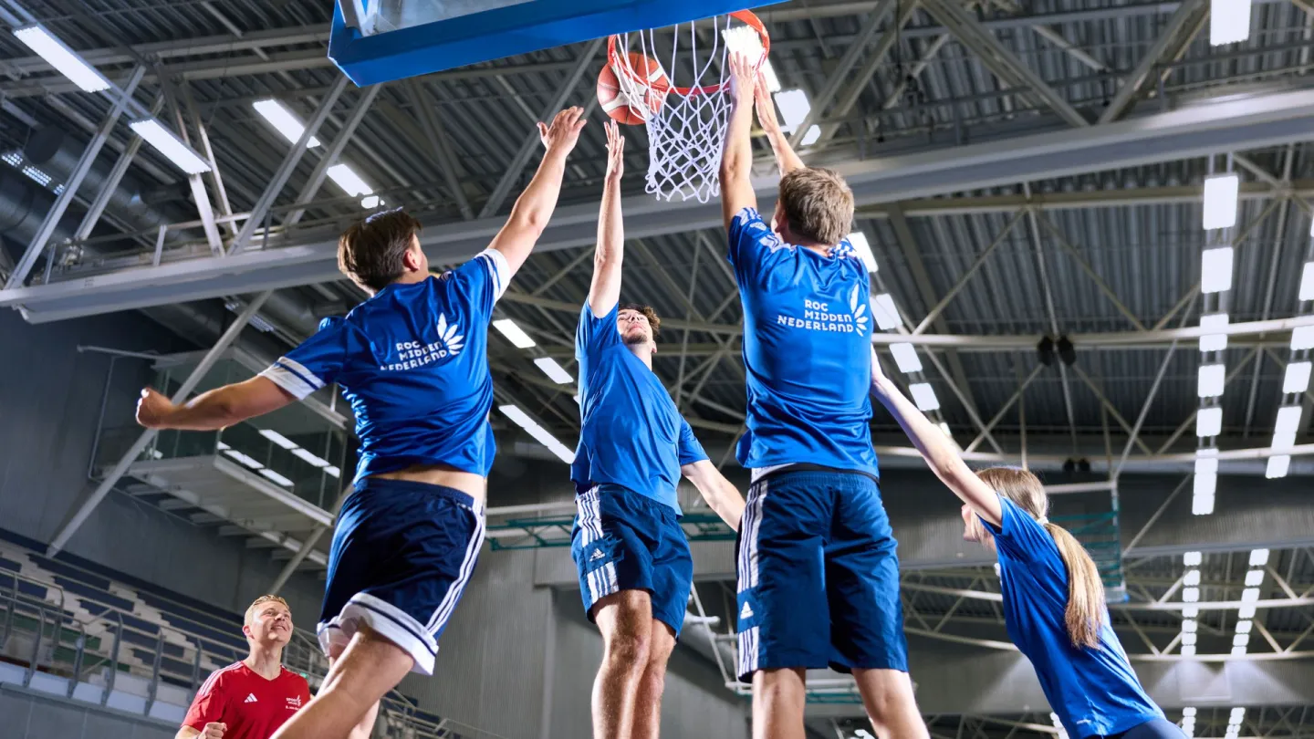 Studenten Sport College basketballen met elkaar in sporthal