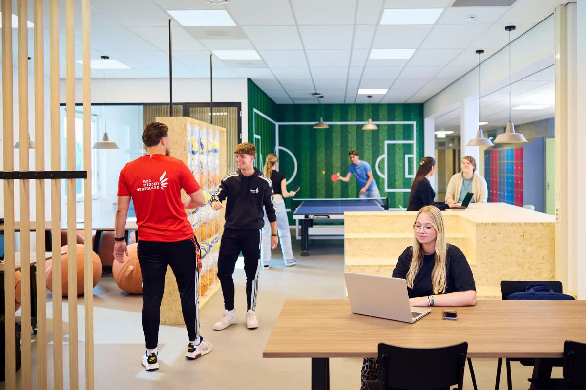 Studenten praten, tafeltennissen en studeren in de centrale ruimte van Campus Amersfoort van ROC Midden Nederland