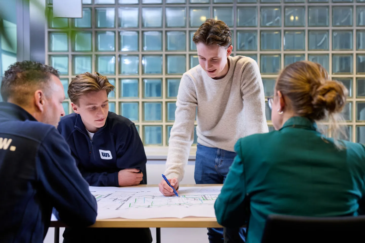 Collega's werken samen aan bouwtekeningen smart building