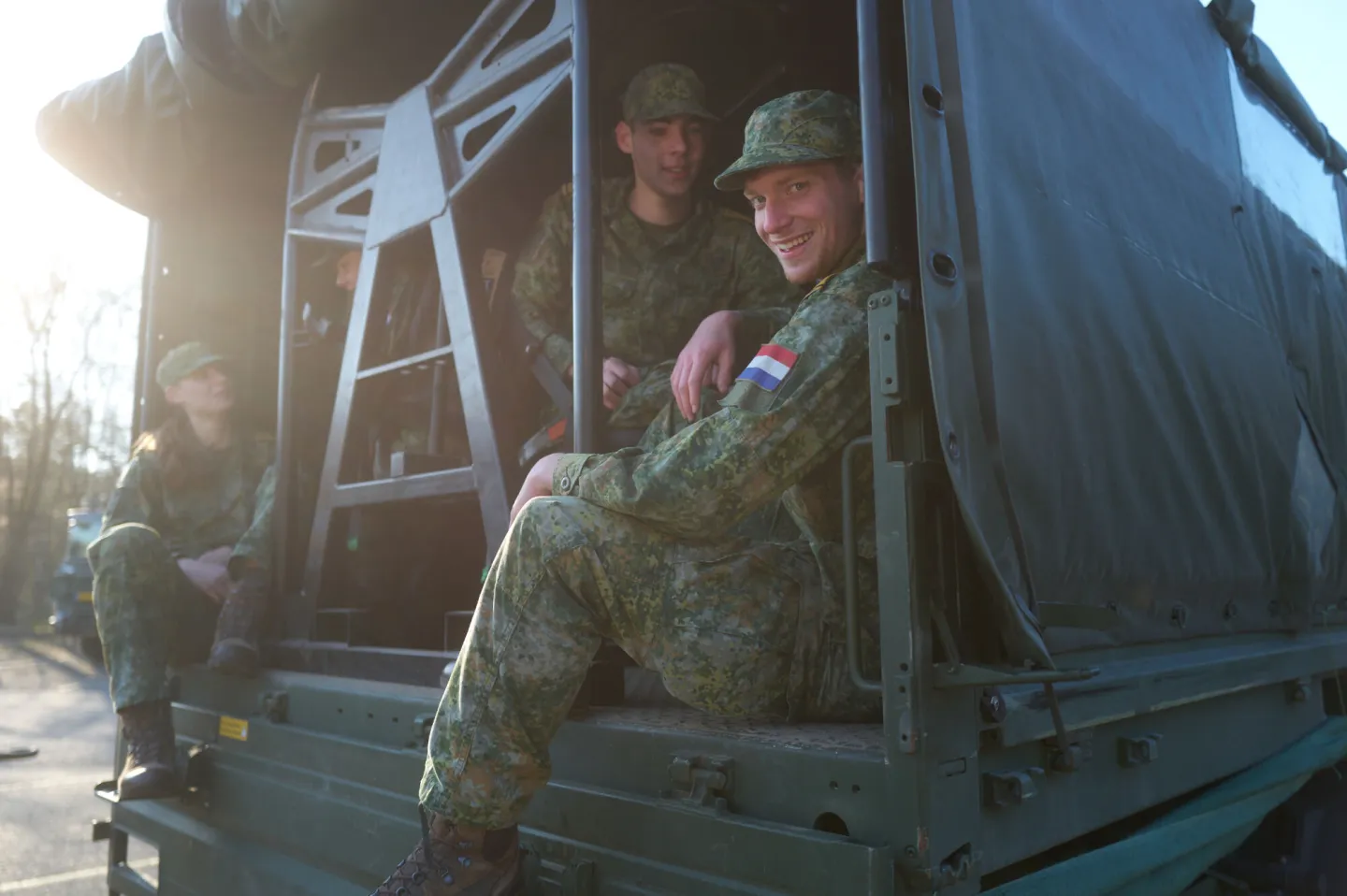 Groepsfoto VEVA-studenten Defensie zitten samen in legertruck