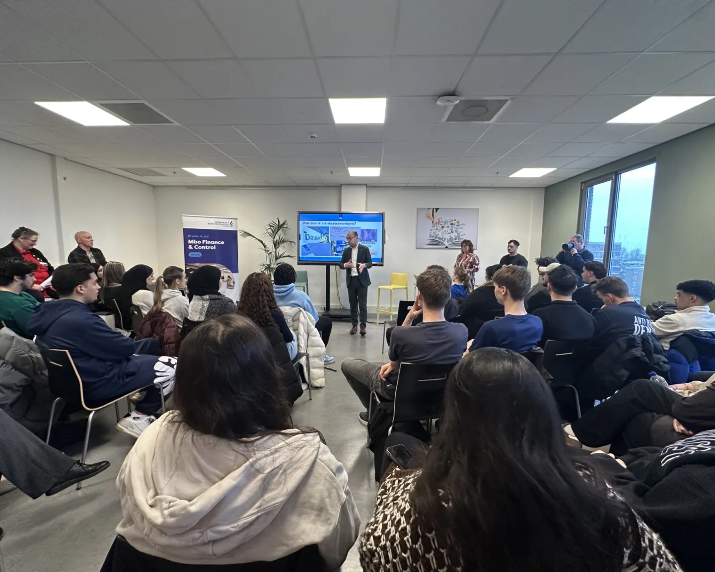 Staatssecretaris Eerenburg geeft gastles belastingaangifte aan studenten op school