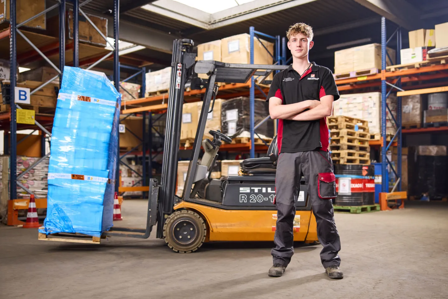 Student Logistiek poseert voor een heftruck