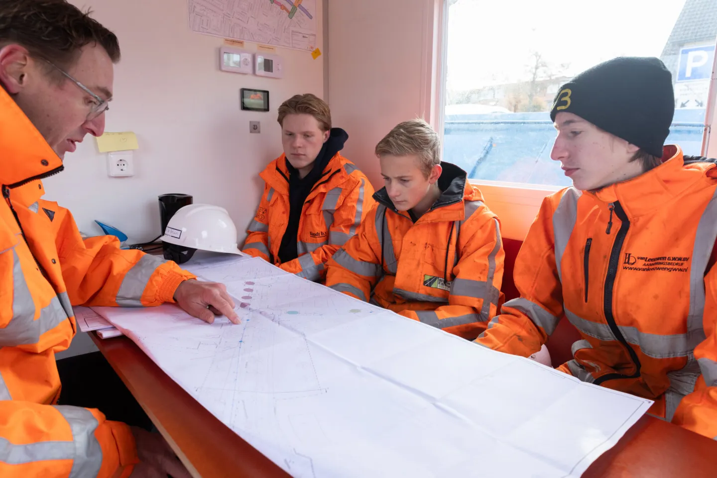 Studenten Infra overleggen in de bouwkeet