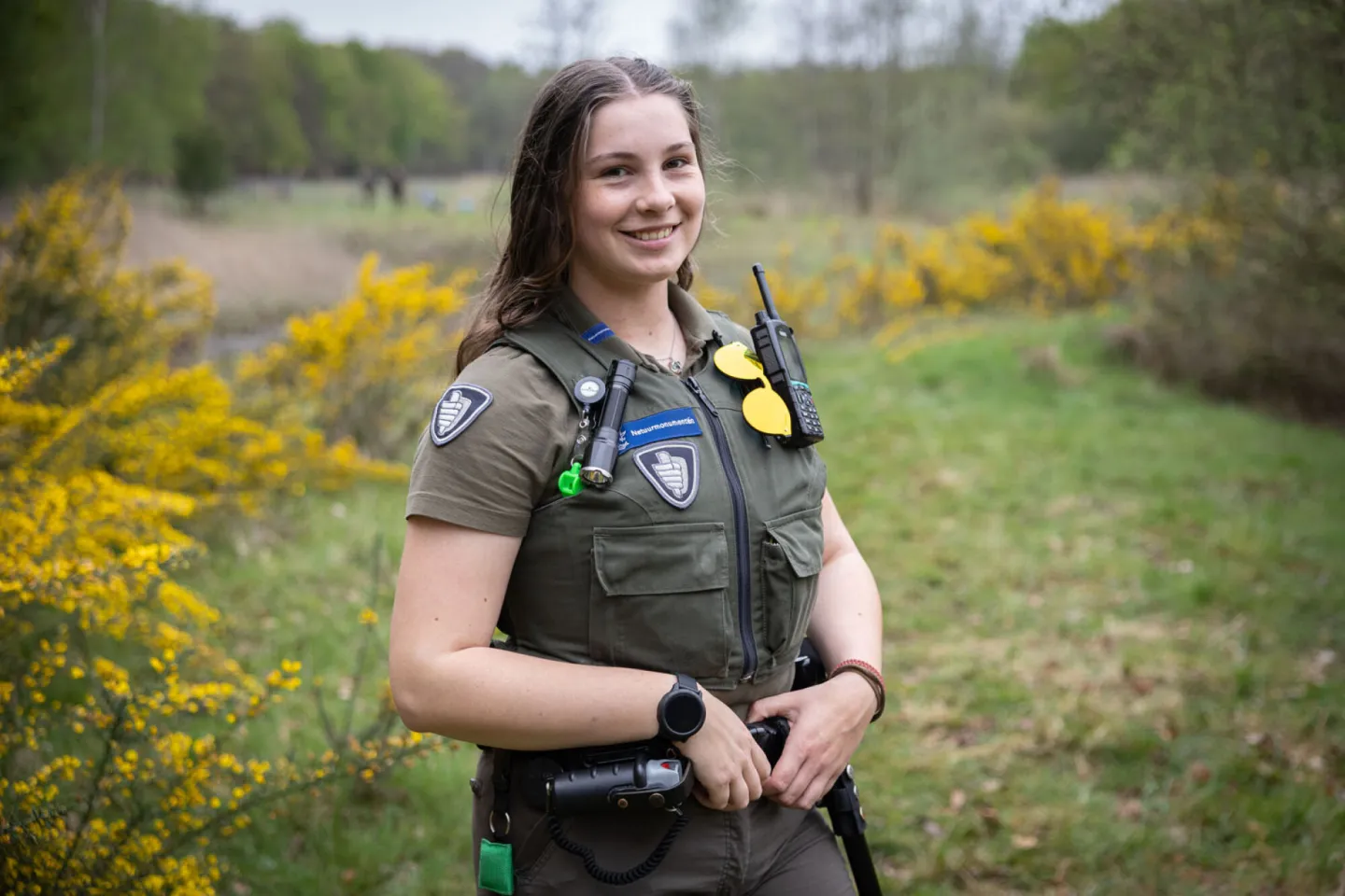 Jonge boswachter poseert trots in natuurgebied