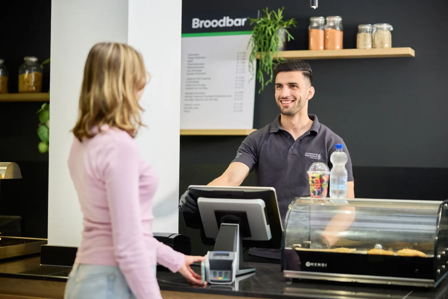 Student helpt klant bij broodbar