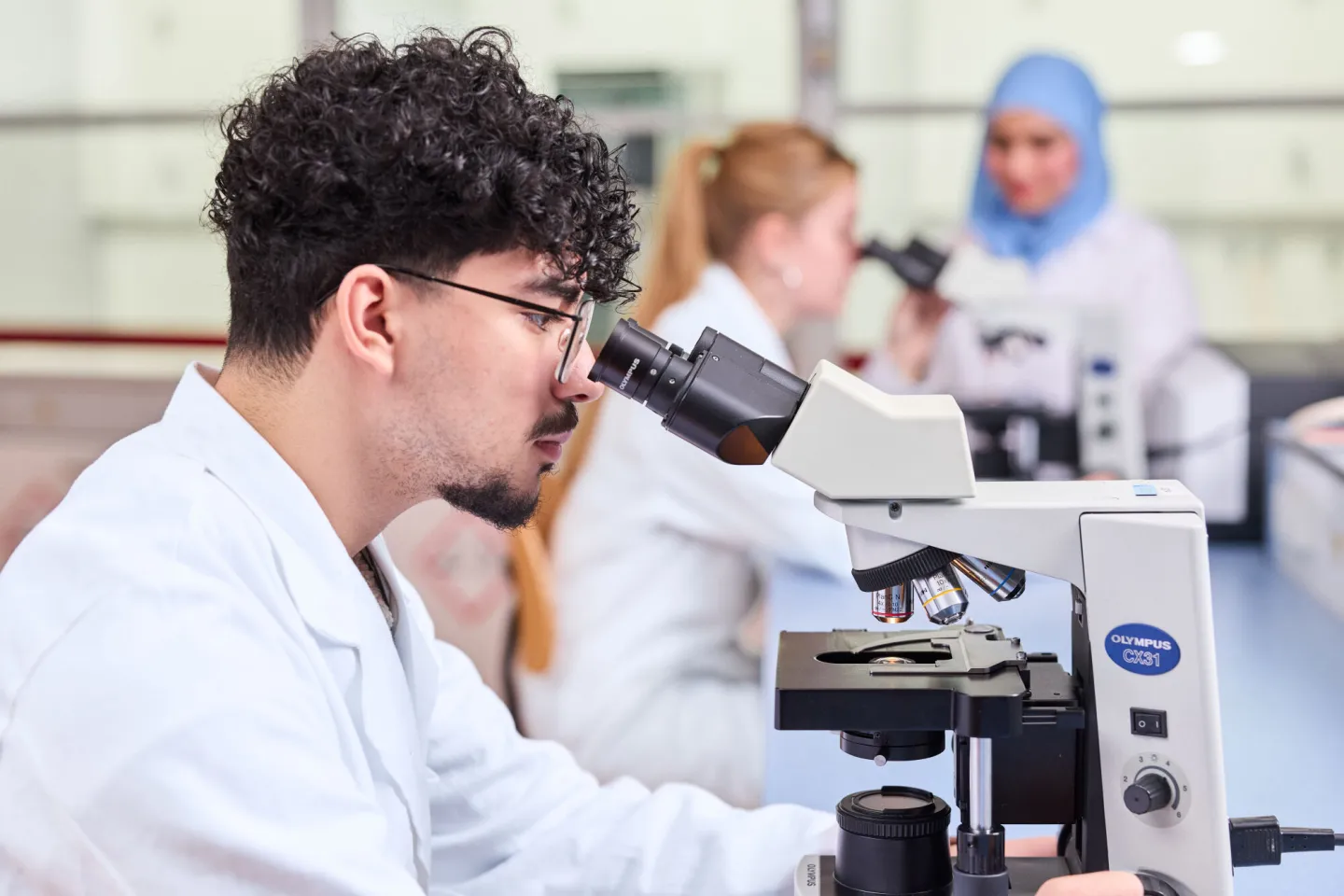 Student Laboratoriumonderwijs kijkt in microscoop