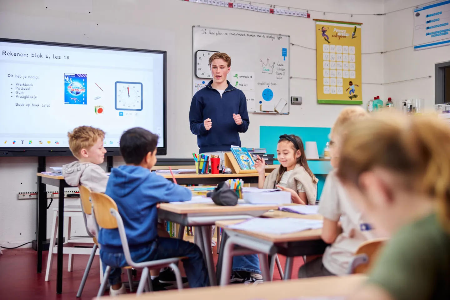 Onderwijsassistent staat voor de klas op stageplek
