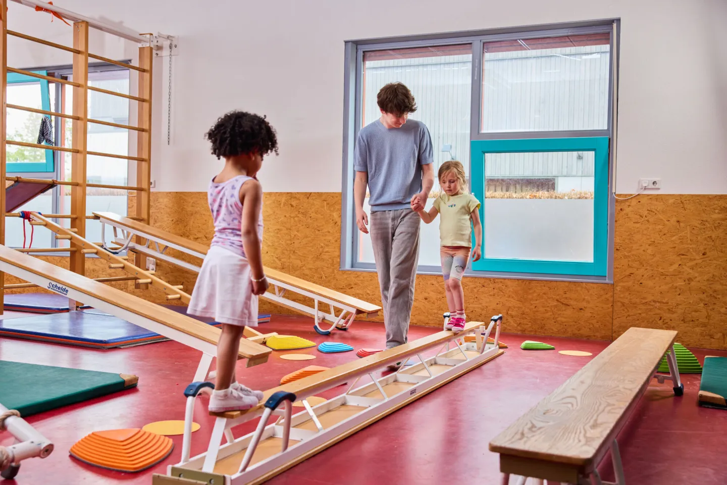 Student begeleidt kinderen tijdens de gymles