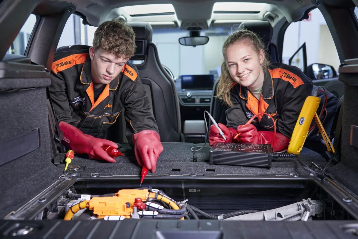 Studenten Autotechniek aan het werk in een auto
