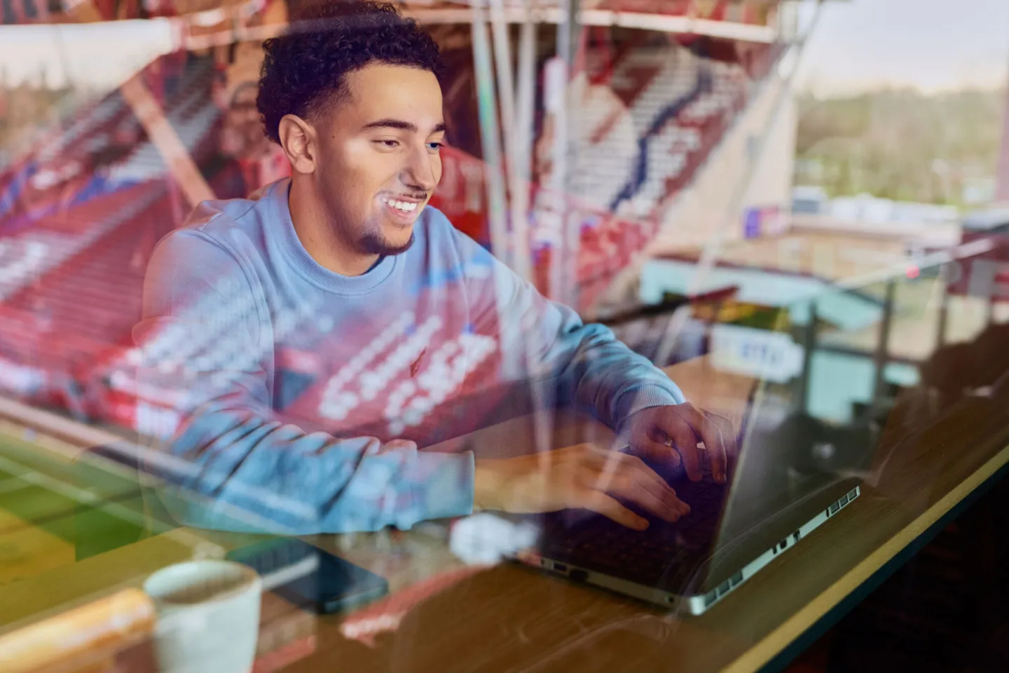 Student Sport Marketing werkt achter laptop in sportomgeving