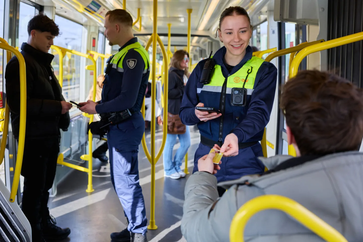 Student Handhaving checkt vervoersbewijs reiziger in tram