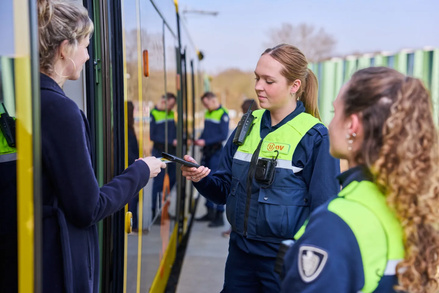 Student Handhaving controleert vervoersbewijs reiziger bij uitstappen