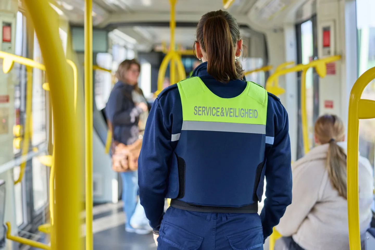 Student Handhaving loopt door tram onder begeleiding van ov-boa
