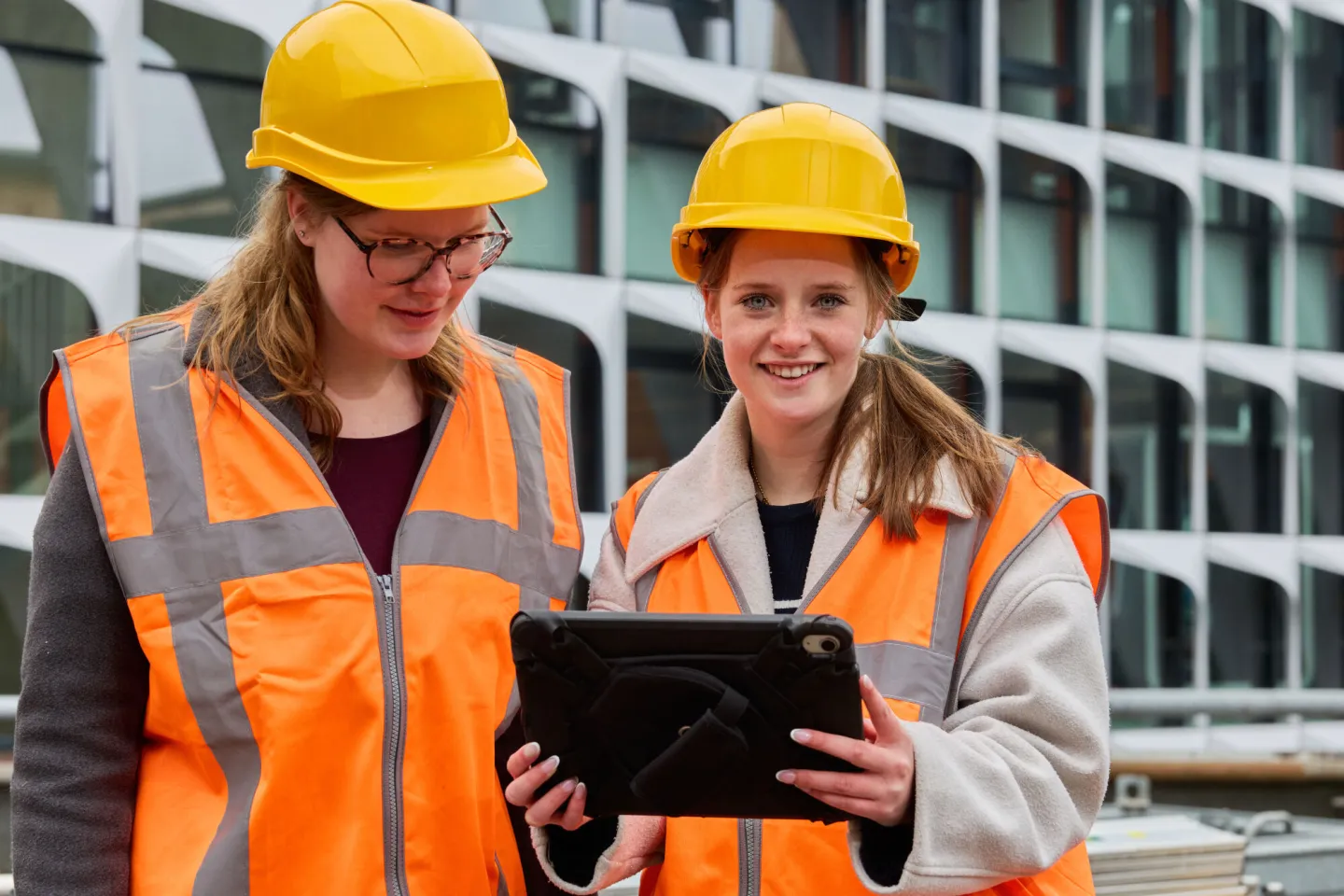 Student kijkt op van tablet en lacht