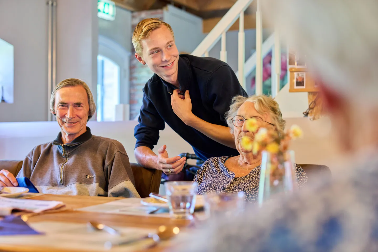 Student Maatschappelijke zorg praat met ouderen tijdens de lunch