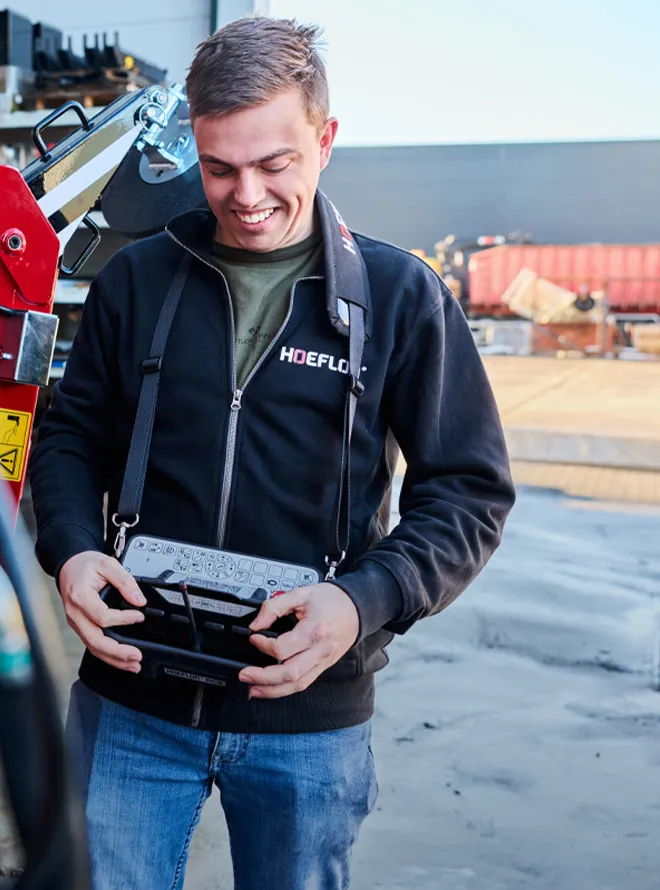 Student bedient machine met afstandsbediening op industrieterrein