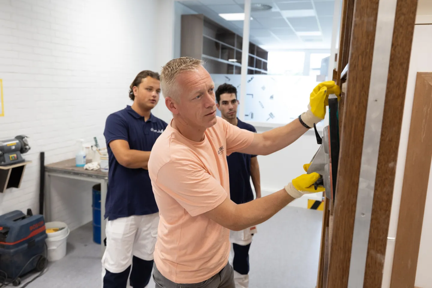 Docent geeft les aan studenten Schilder in het praktijklokaal