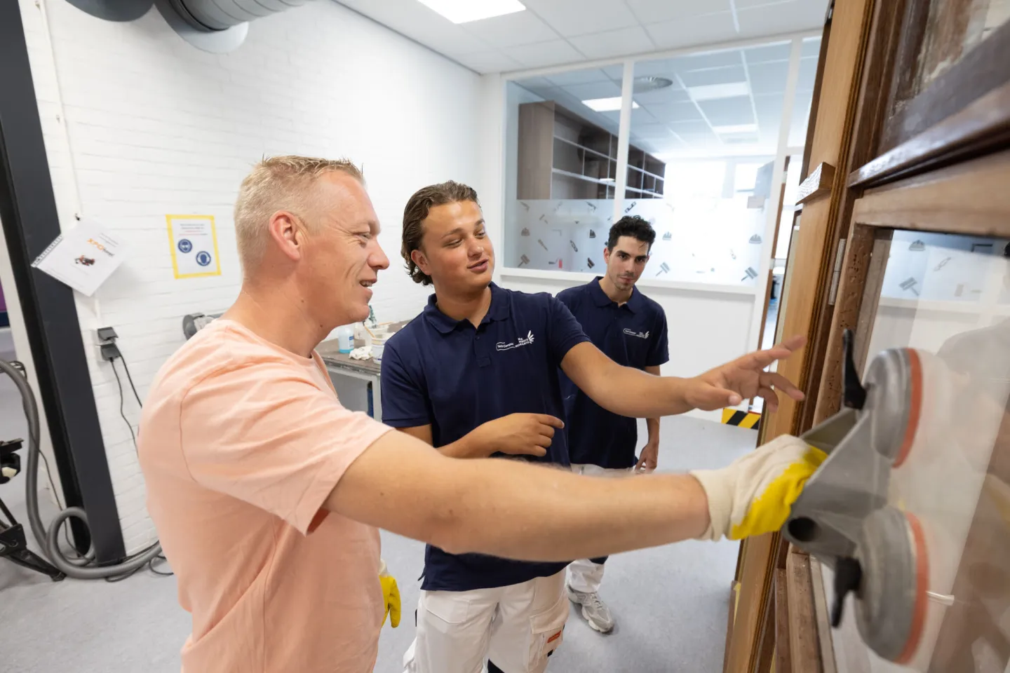 Studenten Schilder krijgen uitleg van een docent in het praktijklokaal