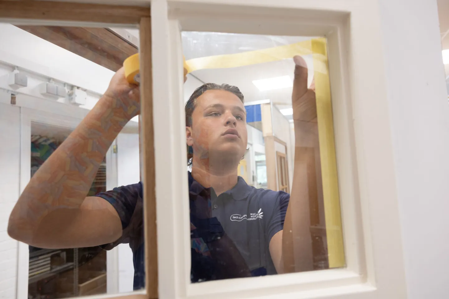 Student Schilder plakt kozijn af met tape