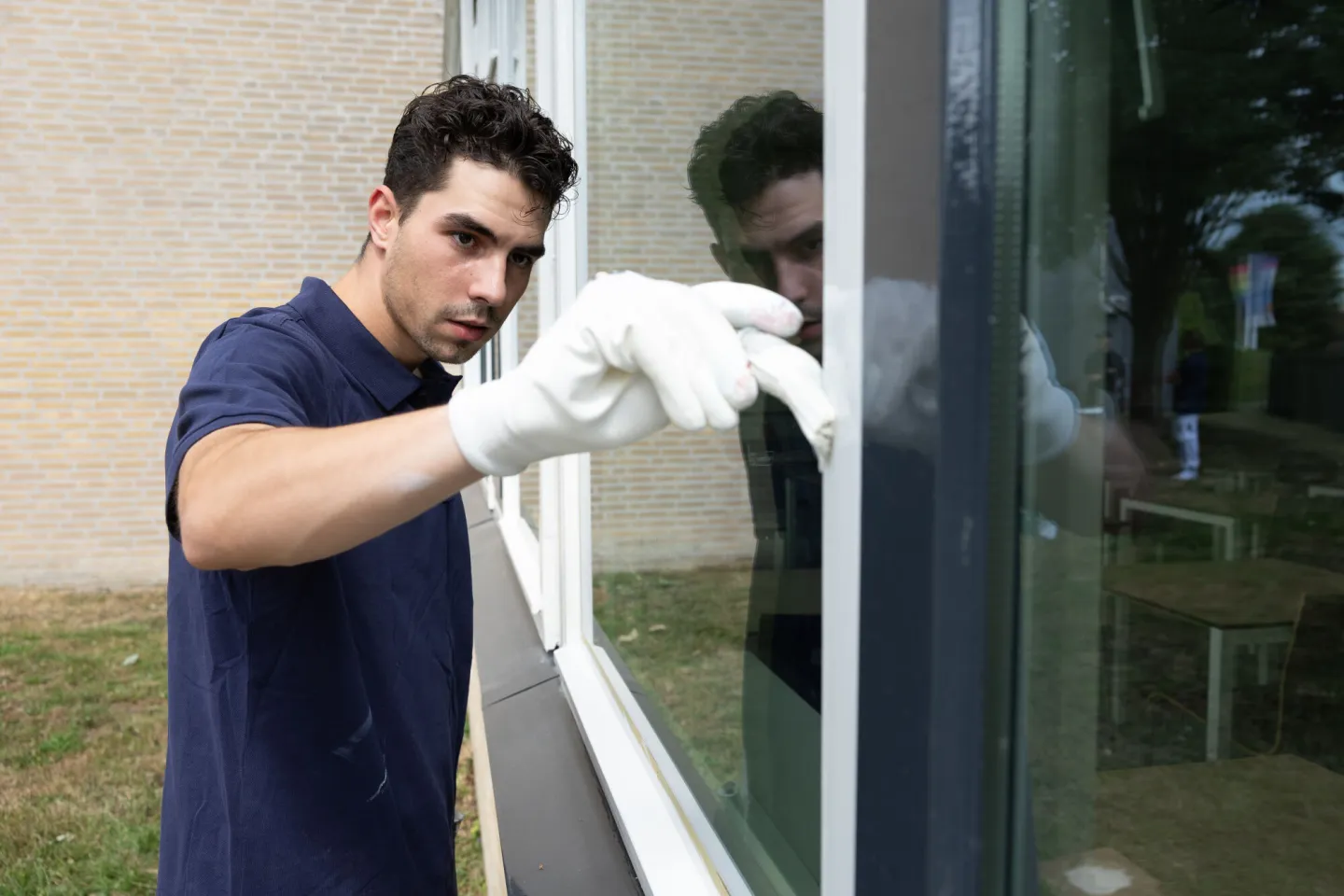 Student Schilder schildert een kozijn buiten