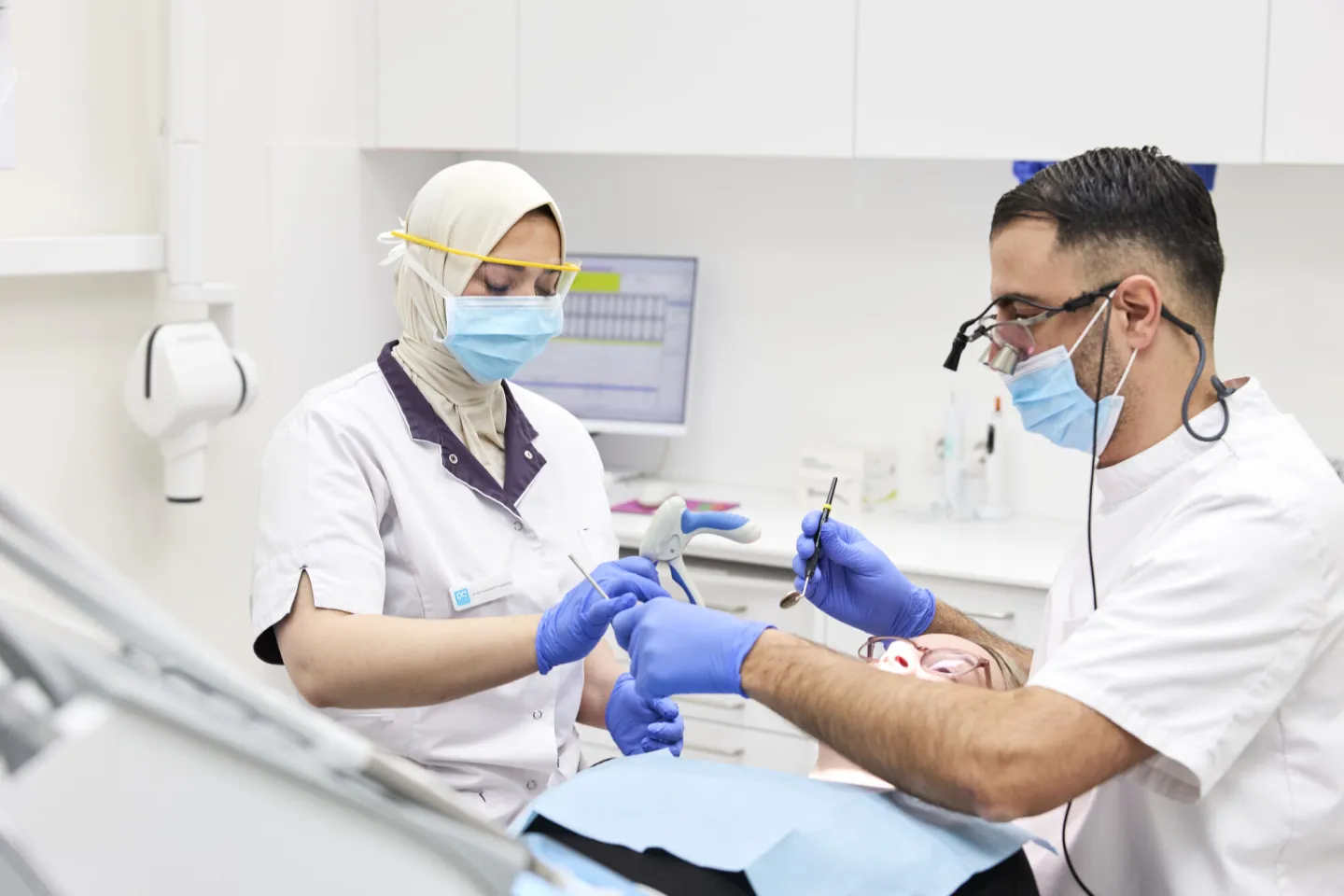 Student Tandartsassistent geeft instrument aan tandarts aan