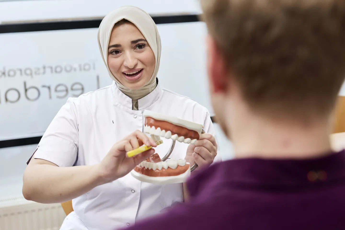 Student Tandartsassistent geeft patiënt poetsinstructies