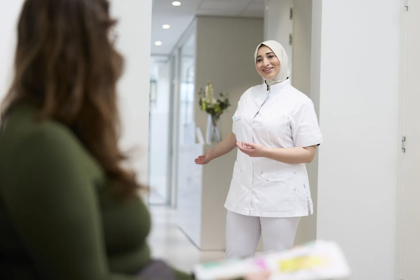 Student Tandartsassistent roept patiënt op in wachtruimte