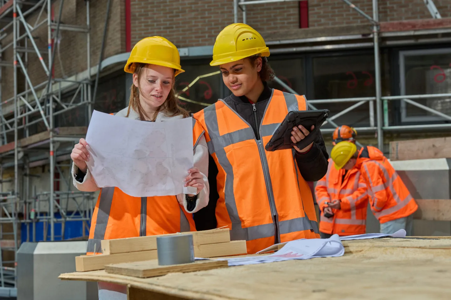 Studenten Bouwkunde overleggen met tekening en aantekeningen tablet