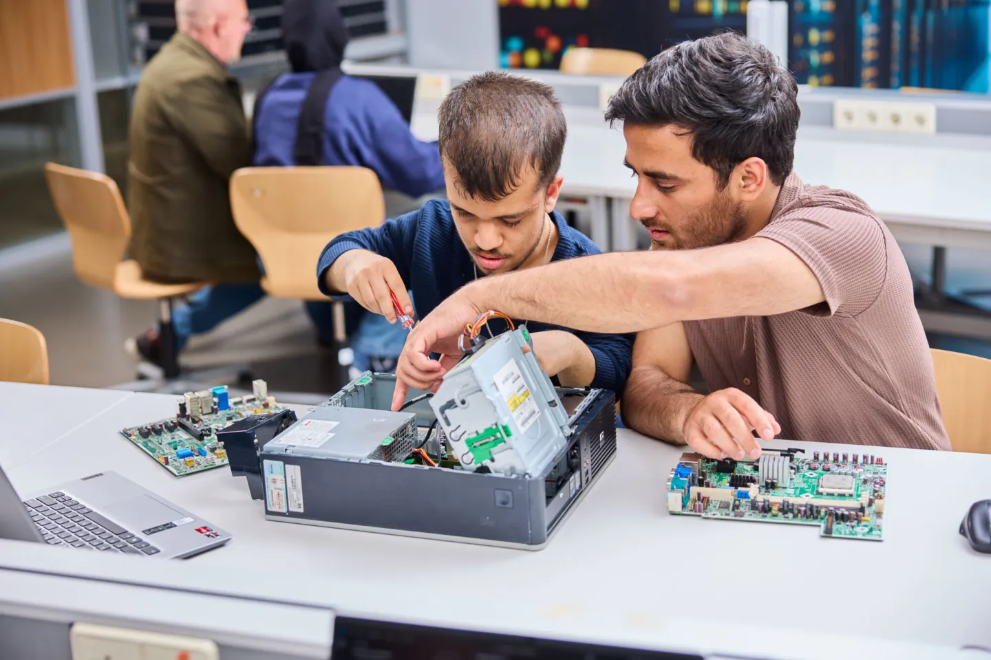Studenten ICT College sleutelen samen aan een computer