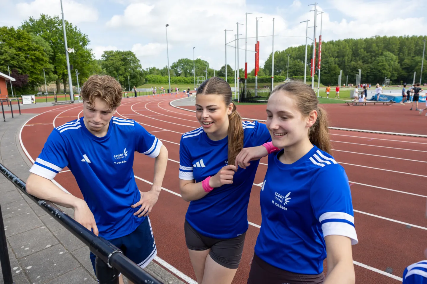 Studenten Sport College staan naast atletiekbaan
