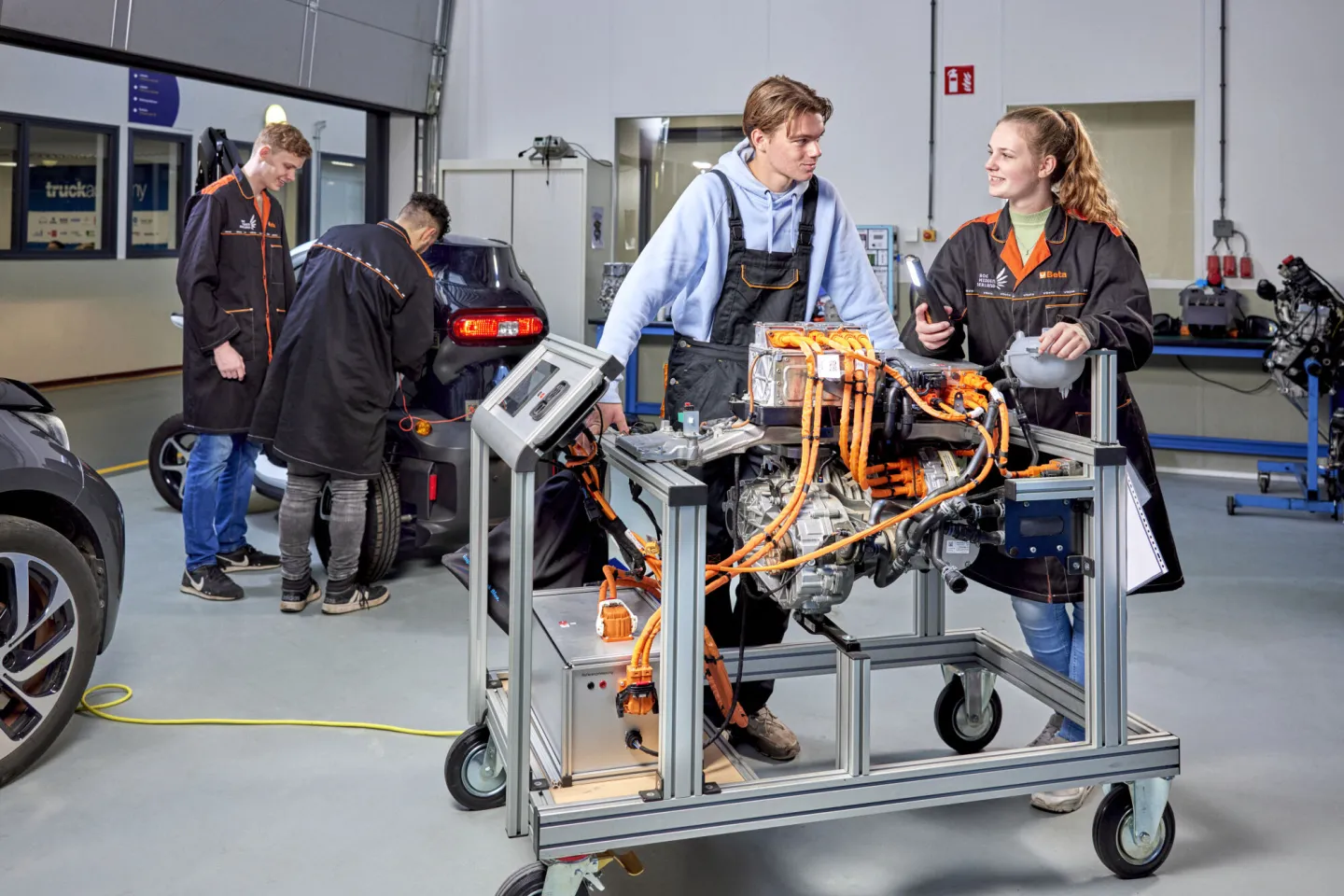 Studenten werken aan motorblok in werkplaats