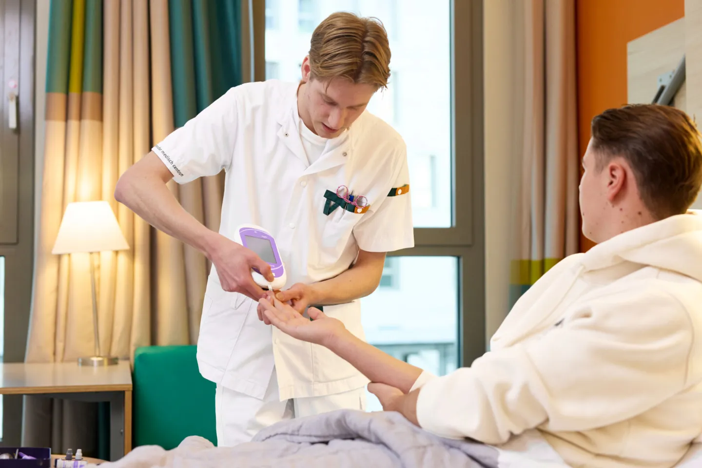 Student Verpleegkundige prikt bloed bij patiënt