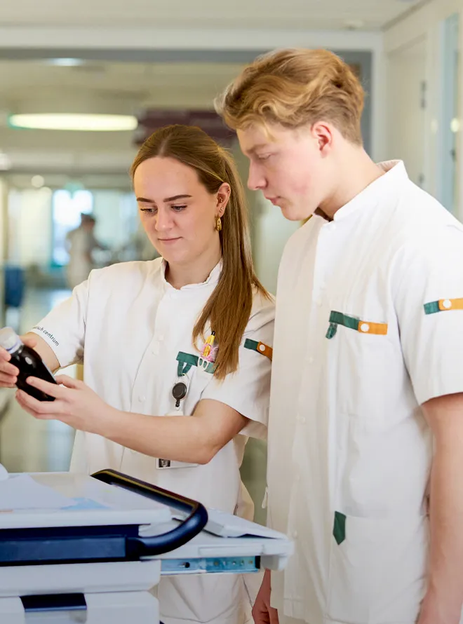 Twee studenten verpleegkunde controleren samen medicatie in een zorgpraktijk