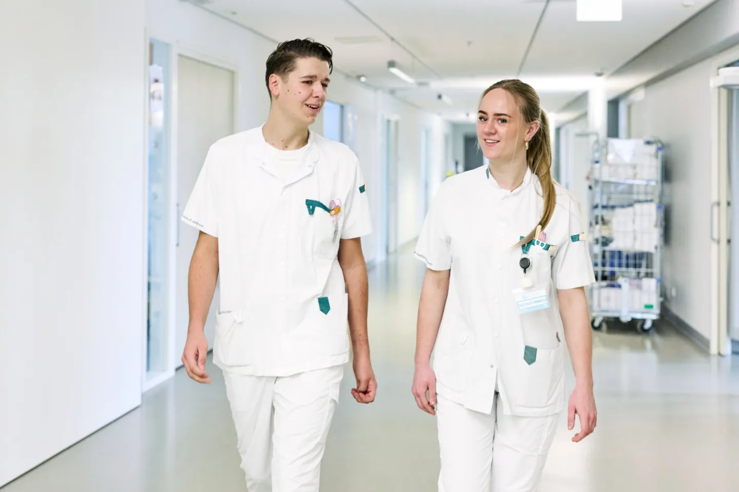 Studenten Verpleegkundige lopen samen in gang ziekenhuis