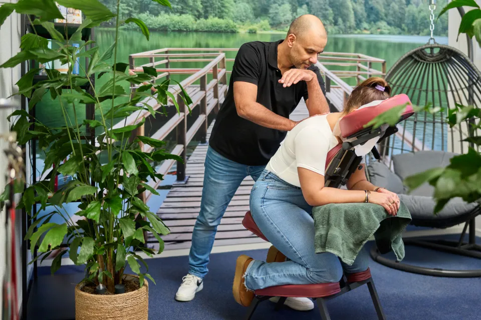Masseur geeft klant stoelmassage met elleboog op rug