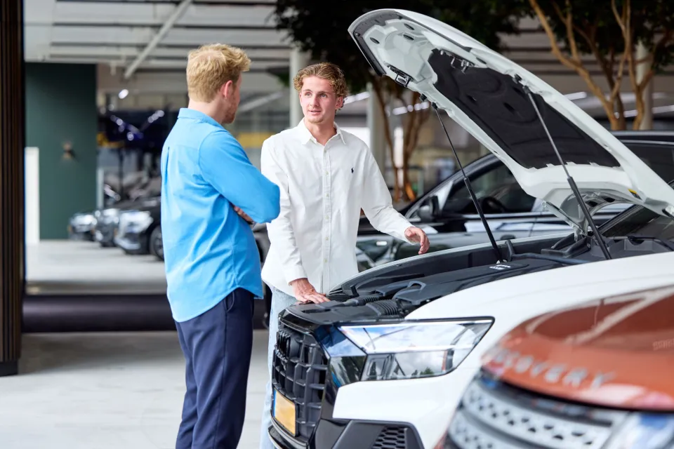 Student Verkoopmanager praat met mogelijke klant over een auto