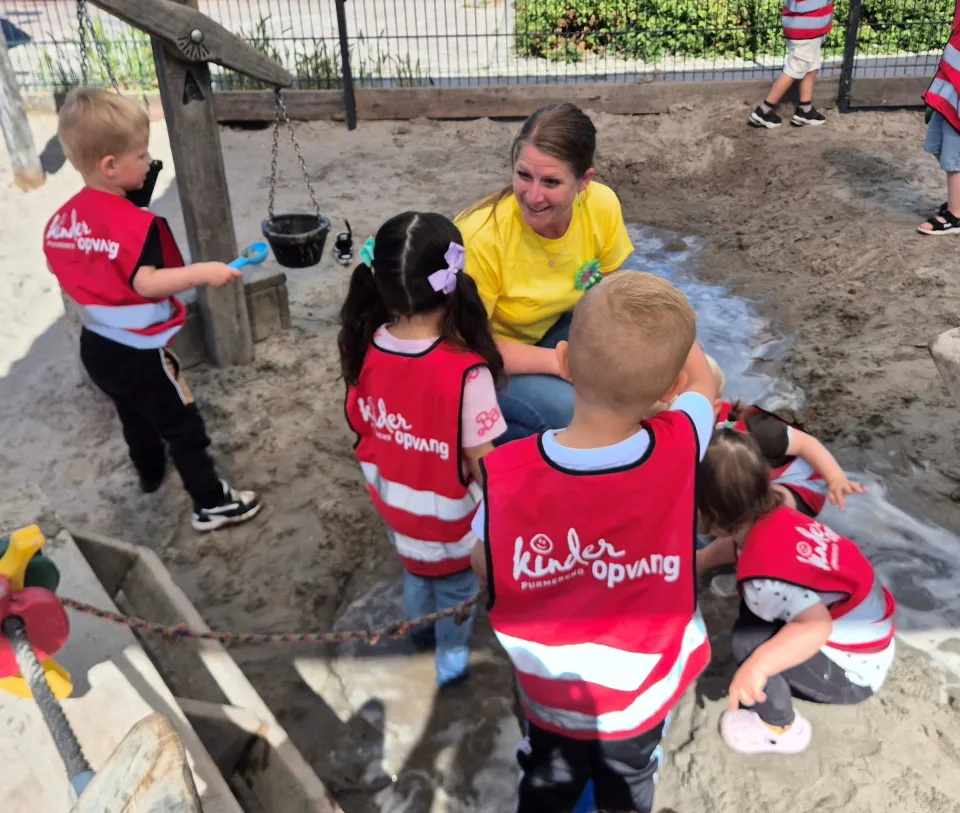 Wendy Jong, oud-student certificaten pedagogisch medewerker, met kinderen in zandbak