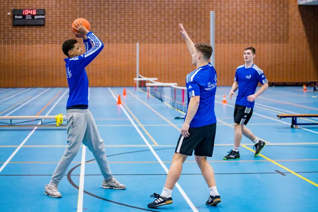 Studenten Sport College zijn aan het basketballen