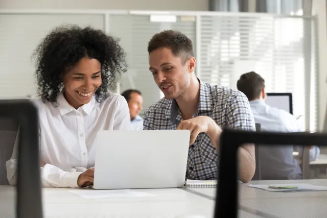 Twee cursisten zijn samen aan het werk achter de laptop