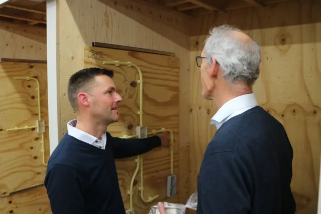 Een student en docent samen aan het overleggen bij elektrokast