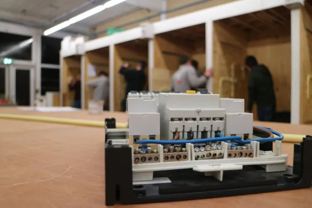 Elektrotechnische machine met studenten op de achtergrond