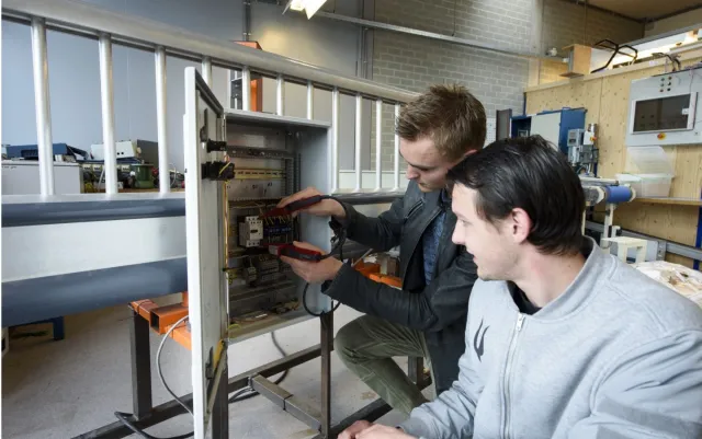 Studenten Monteur elektrotechnische installaties krijgen les in een praktijklokaal