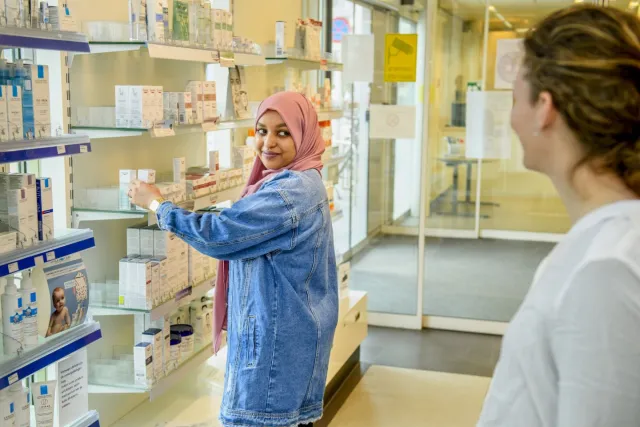 Apothekersassistent pakt medicijnen voor klant in apotheek.