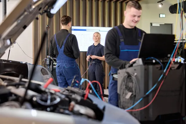 Studenten Automotive College werken samen in een werkplaats voor auto's